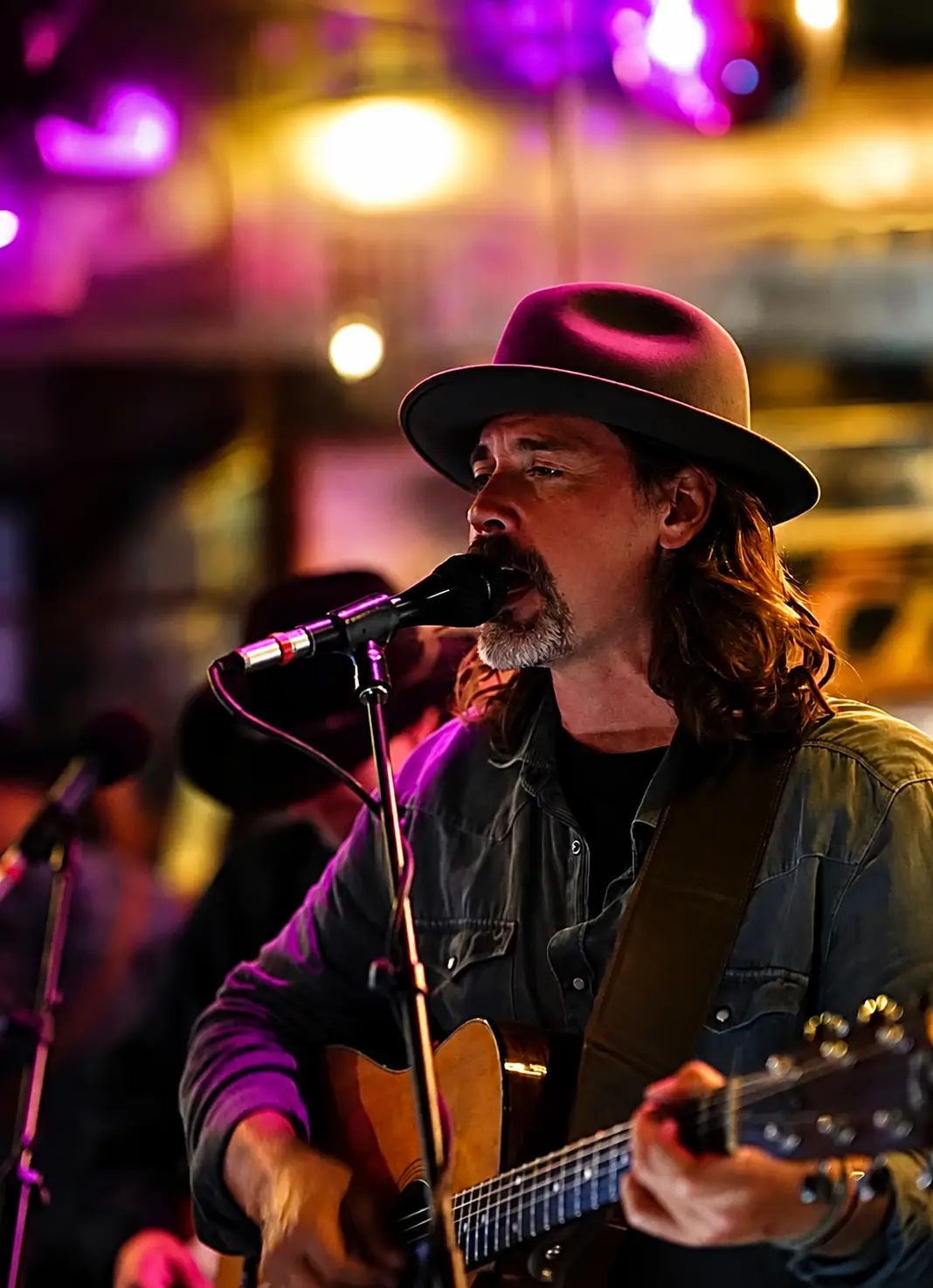 A singer and guitarist performing under colored stage lights at Patrick Molloy's.