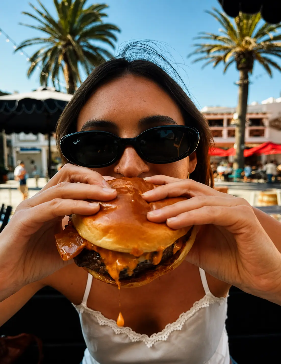 A woman on the patio biting into a big burger at Patrick Molloy's.
